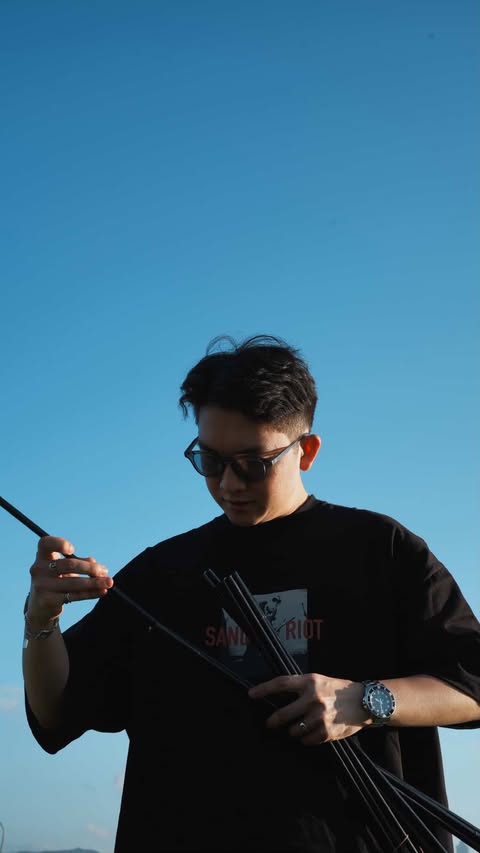 Morris Chung 的個人照：在藍天下低頭整理手上的器材